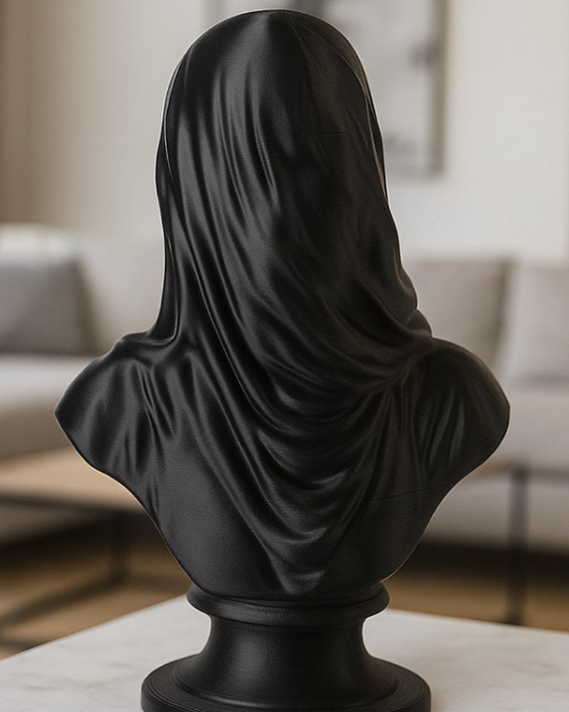 Matte black veiled bust sculpture on a white surface, close-up showing draped veil texture