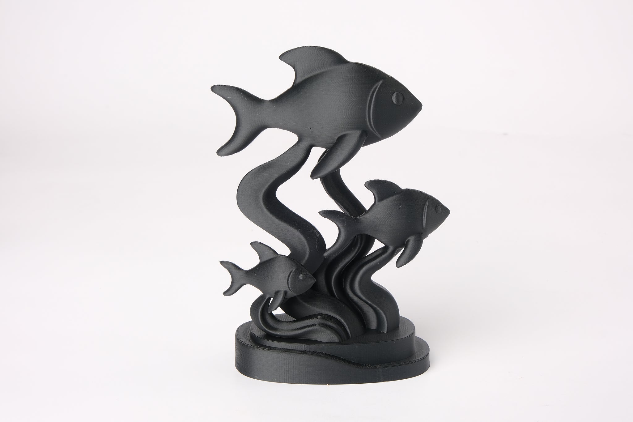 Fish sculpture styled on a wooden shelf alongside ceramics and a small plant