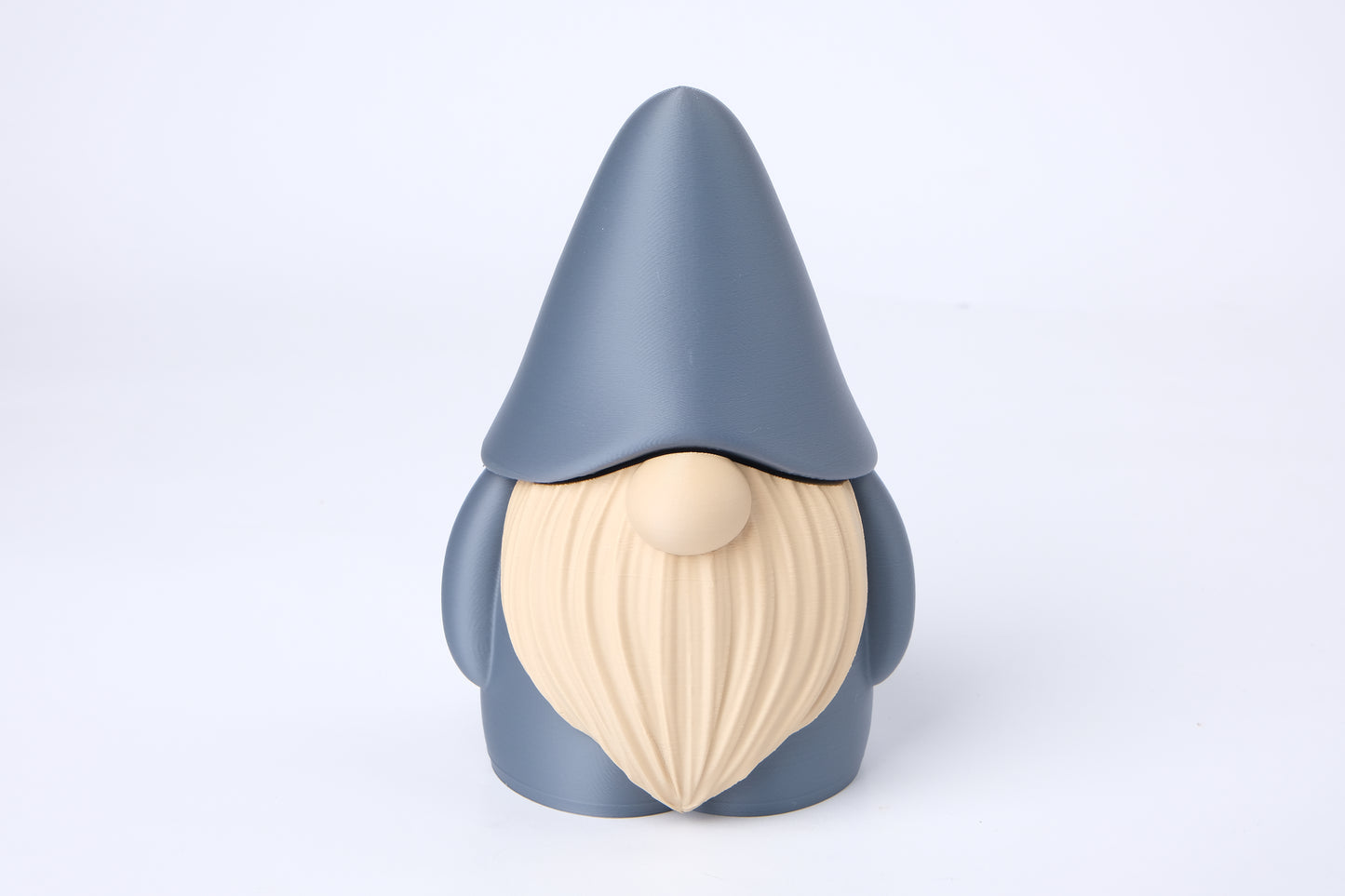 Gnome figurine styled on a bookshelf beside a candle and small plant in a warm, hygge-inspired interior