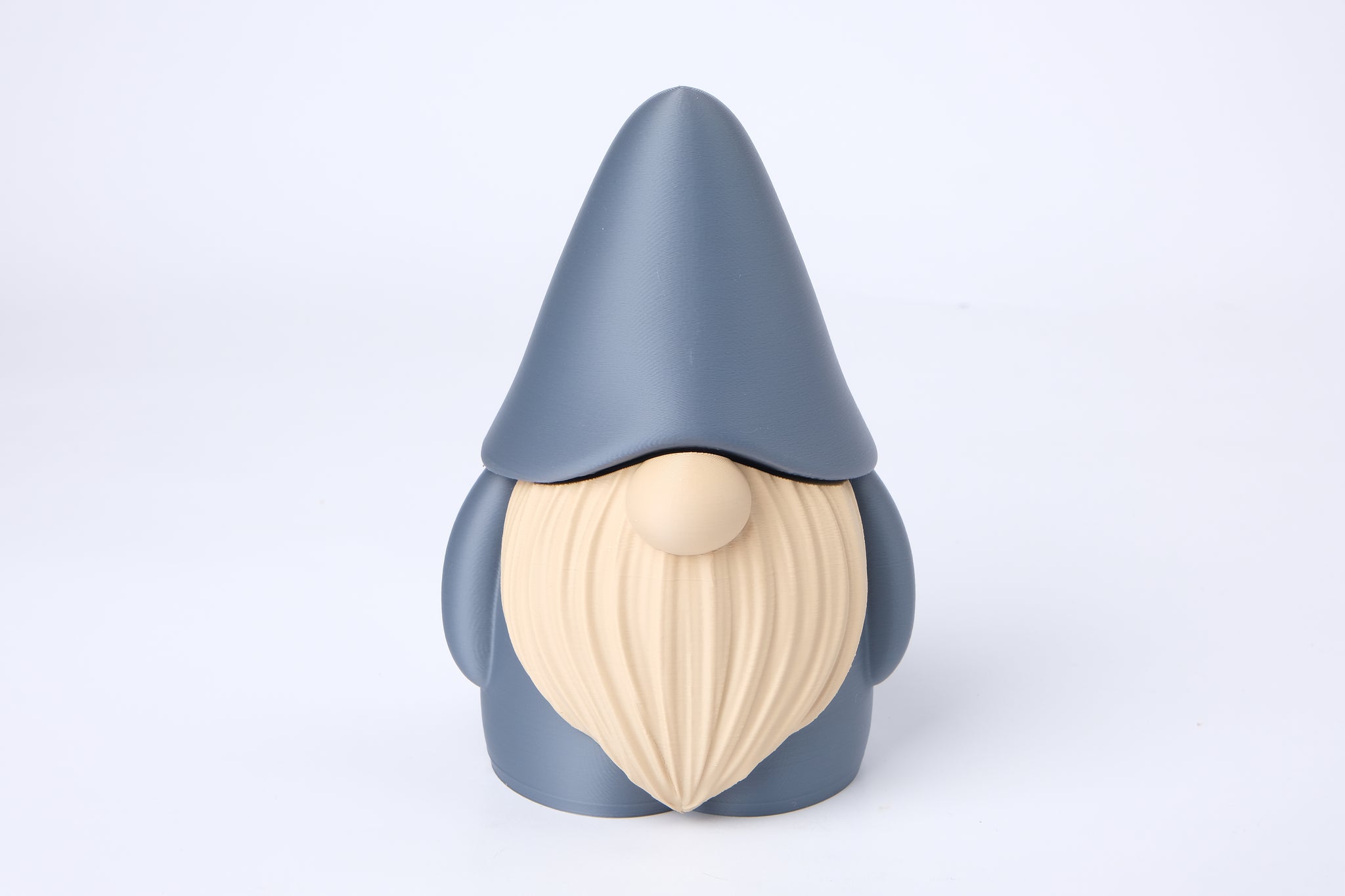 Gnome figurine styled on a bookshelf beside a candle and small plant in a warm, hygge-inspired interior