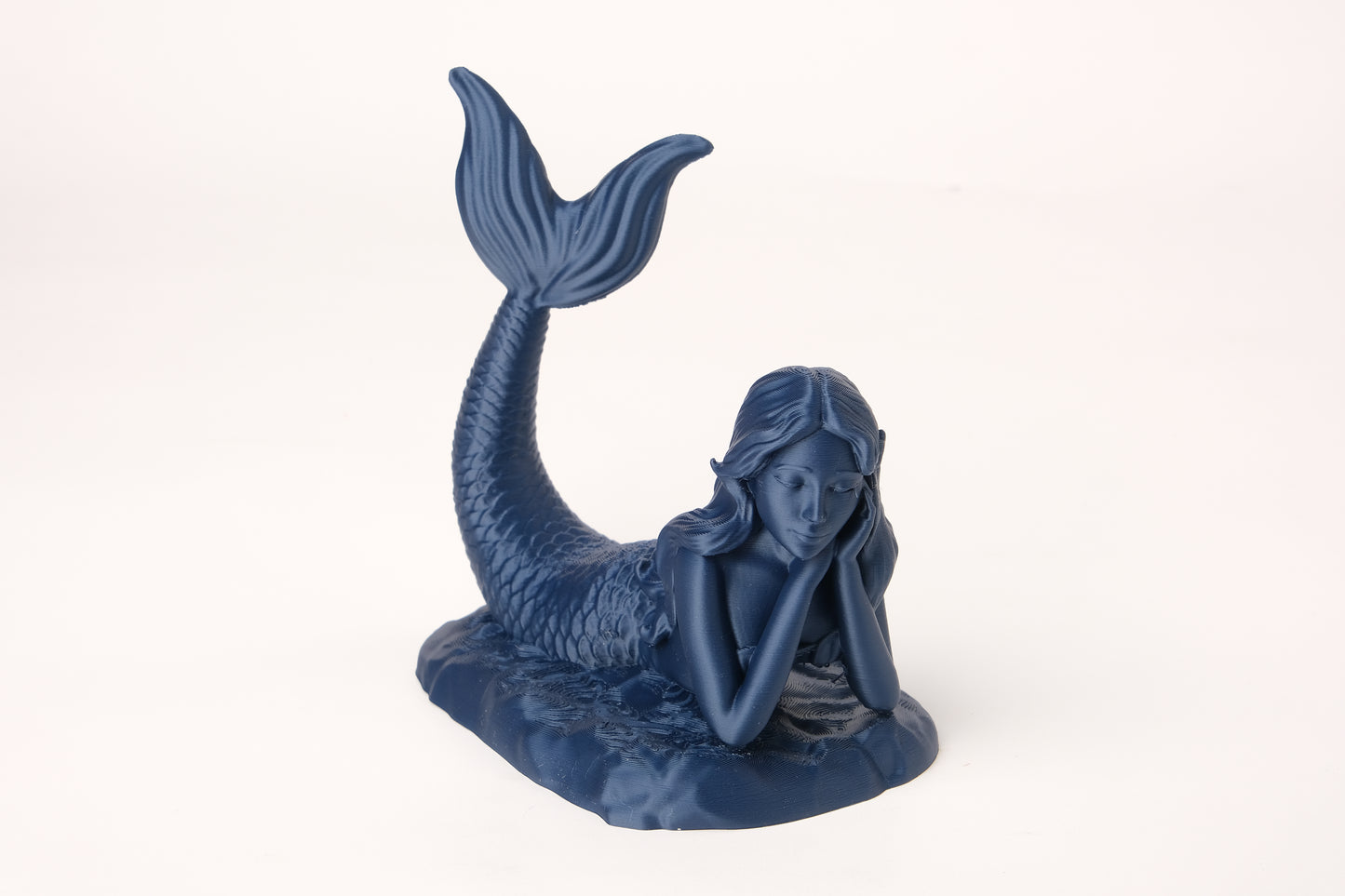 Ethereal mermaid figure styled on a wooden shelf beside coastal home decor
