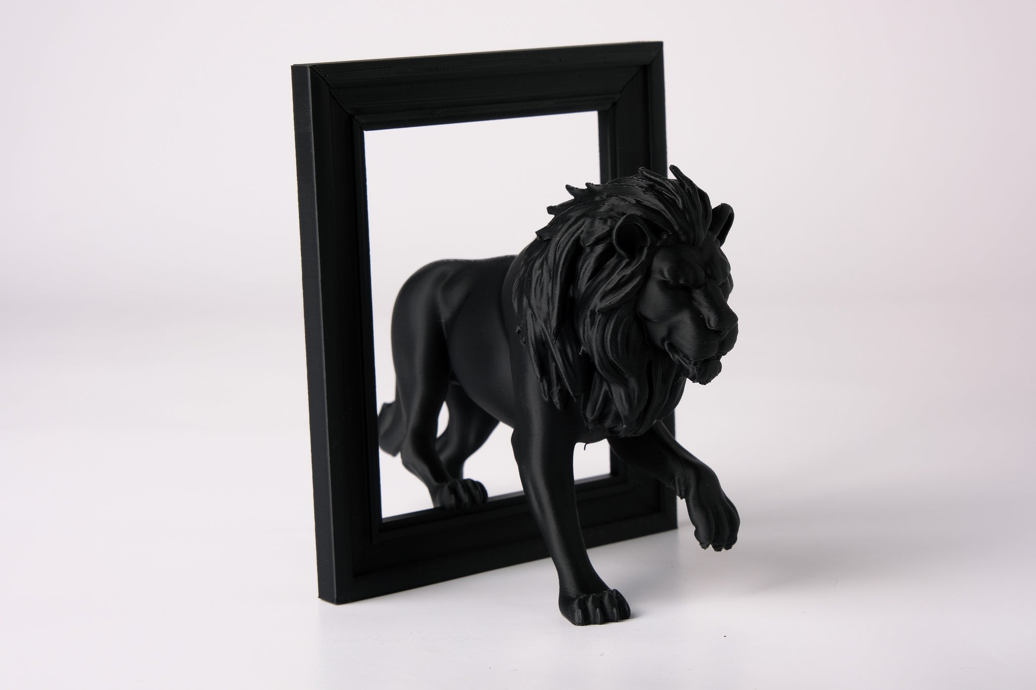 Lion frame sculpture styled on a dark wood shelf beside minimal decor objects