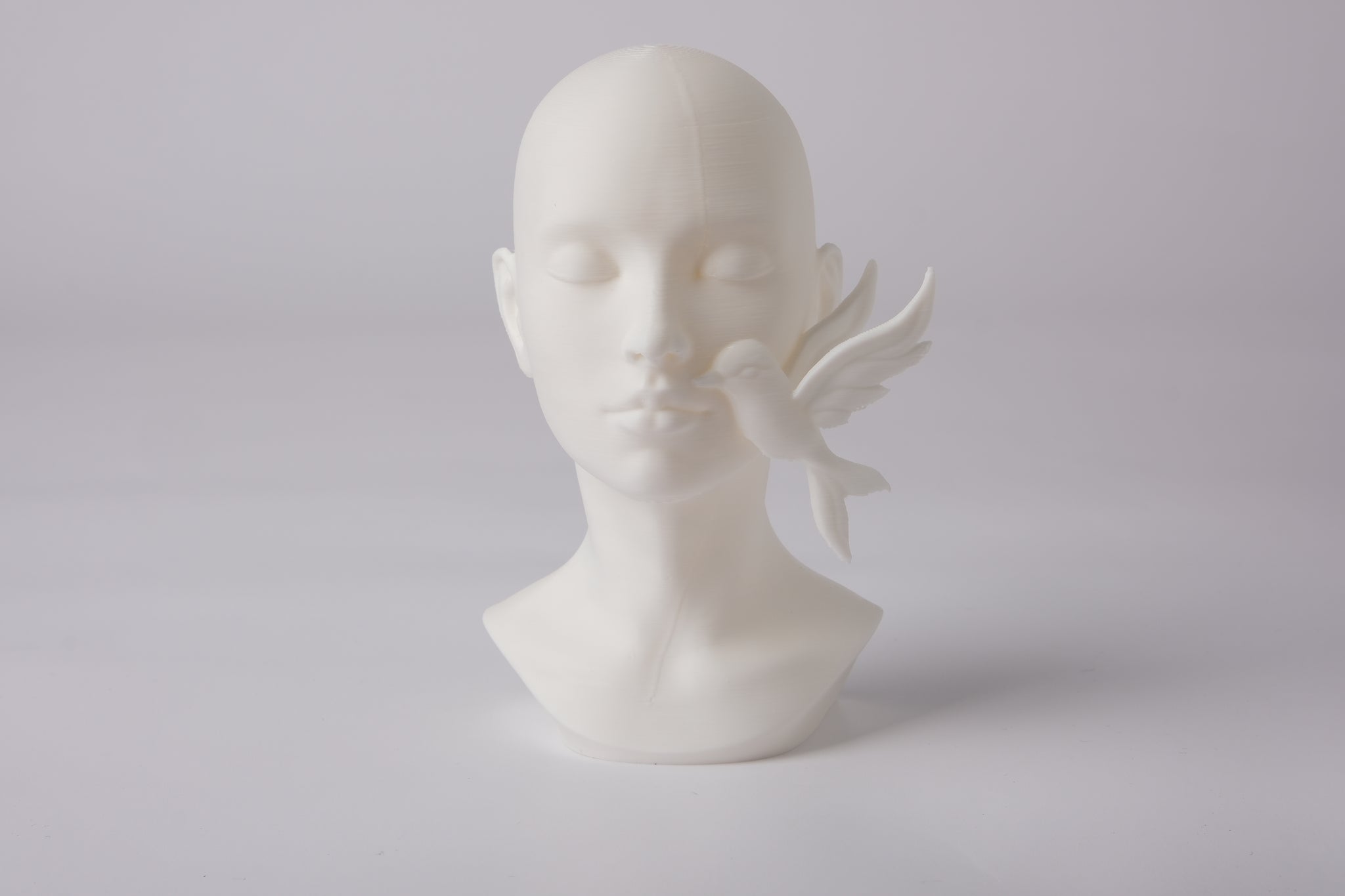 Serenity face sculpture styled on a wooden shelf beside dried botanicals and soft linen