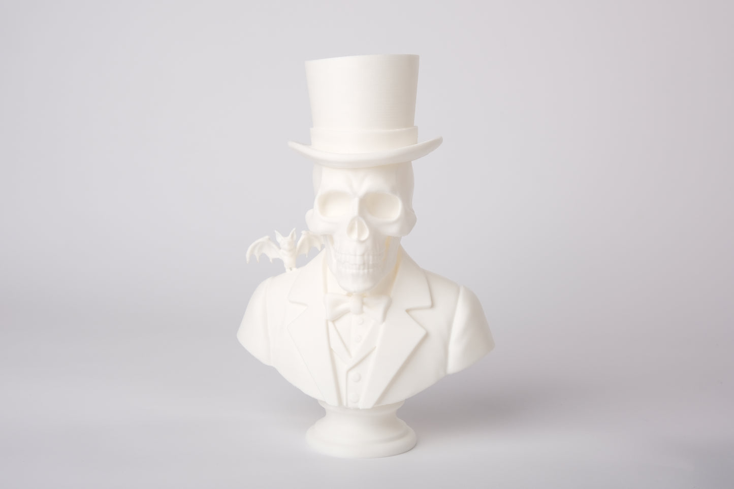 Gothic skeleton sculpture styled on a dark wooden shelf with candles and dried botanicals