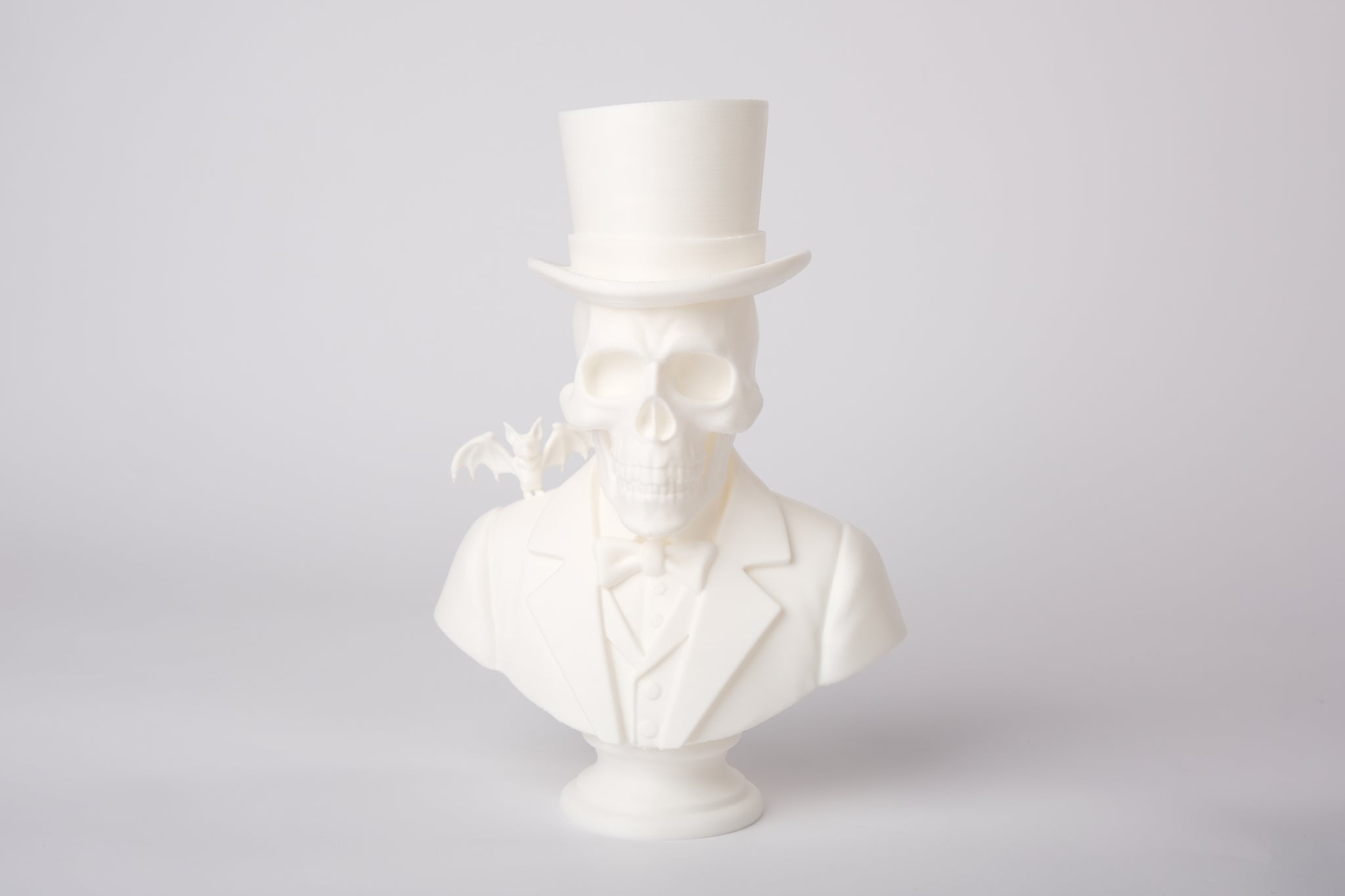 Gothic skeleton sculpture styled on a dark wooden shelf with candles and dried botanicals