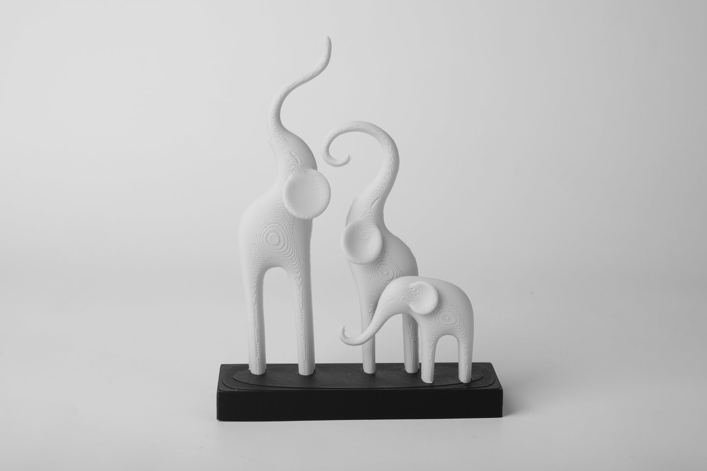 Minimalist elephant family sculpture styled on a light wooden shelf with neutral Scandinavian decor