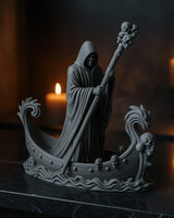 Gothic boat statue of a skeletal ferryman holding a skull staff, front view on white background