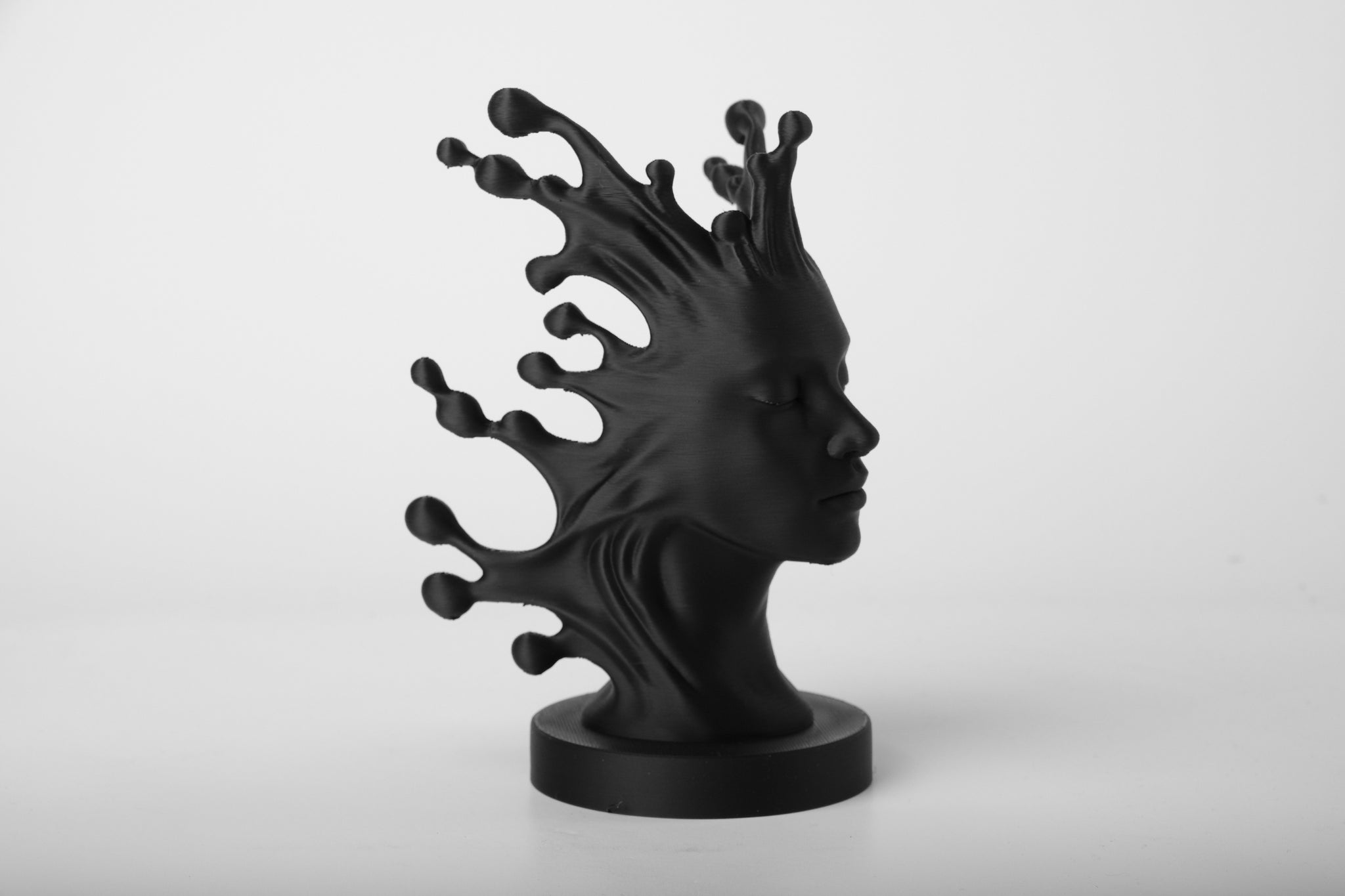 Fluid Mind abstract bust sculpture styled on a wooden sideboard beside a small plant and neutral linen