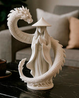 Dragon guardian sculpture close-up — robed figure with coiling dragon, matte white finish