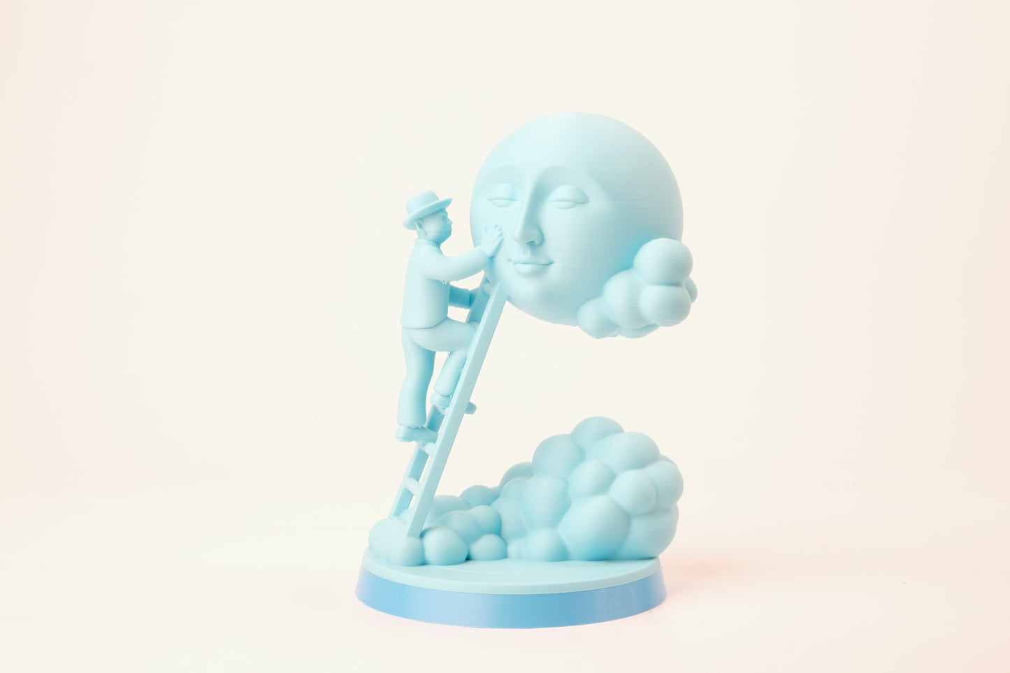 Moon caretaker sculpture styled on a minimalist shelf between books and a small plant