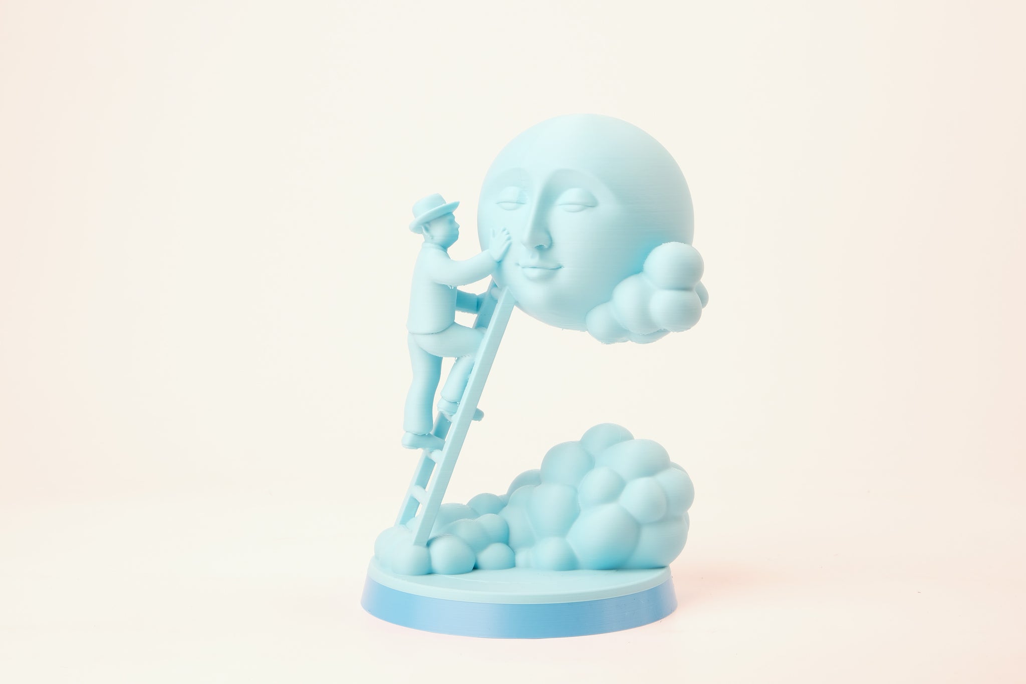 Moon caretaker sculpture styled on a minimalist shelf between books and a small plant
