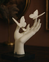Close-up of a butterfly hand sculpture showing smooth surface and delicate butterfly forms, 5.8 cm wide