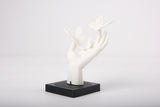 Butterfly hand sculpture styled on a minimalist wooden shelf alongside a small ceramic vase