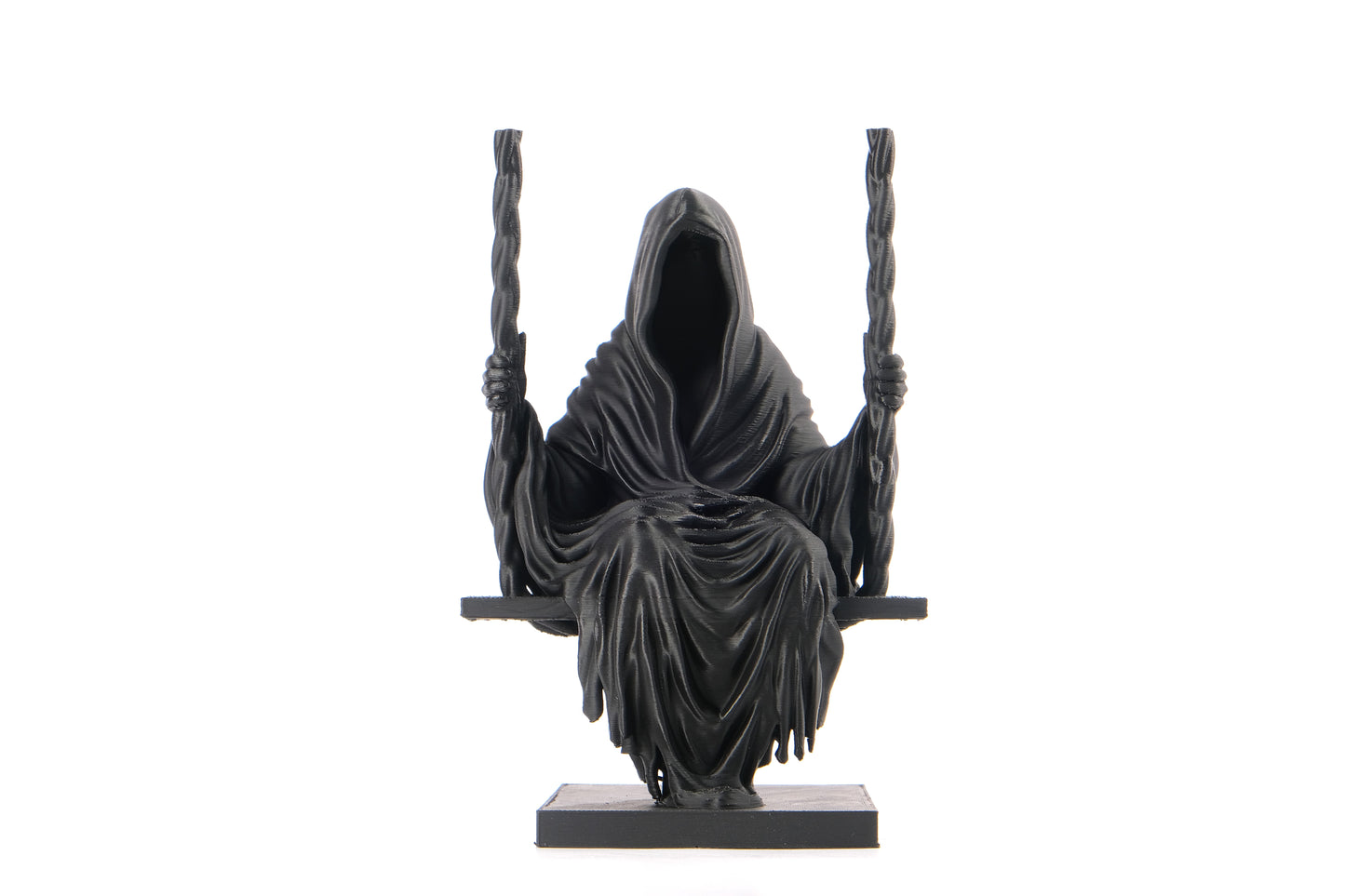 Dark gothic grim reaper sculpture styled on a dark wooden shelf with candles and moody decor
