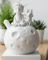 Little prince moon sculpture with fox figurine on a white surface, front view