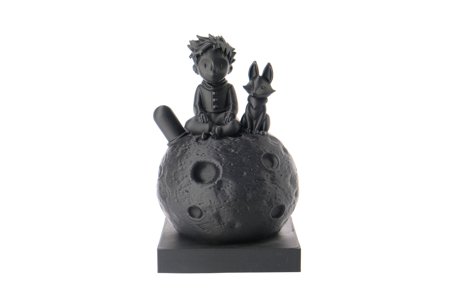 Little prince and fox sculpture styled on a wooden bookshelf beside books