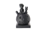 Little prince and fox sculpture styled on a wooden bookshelf beside books