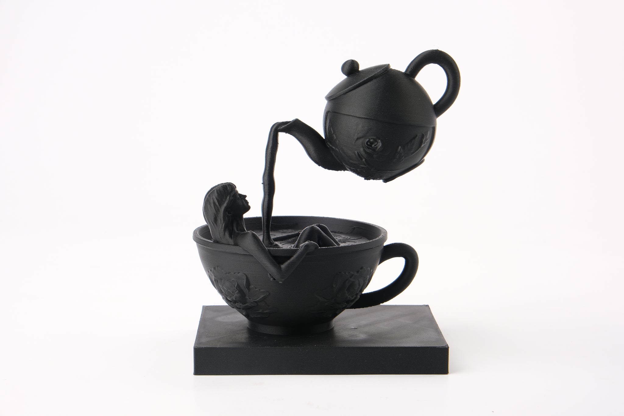 Tea Time Reverie sculpture styled on a dark shelf alongside books and minimal decor objects