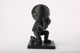 Modern atlas astronaut statue styled on a minimalist desk with books and neutral decor