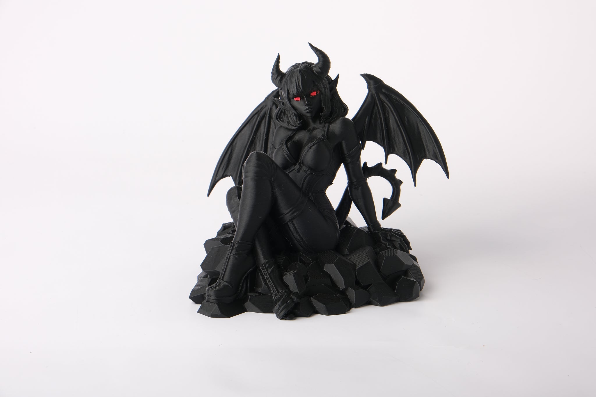 Gothic demonic figure sculpture styled on a dark shelf alongside candles and moody decor