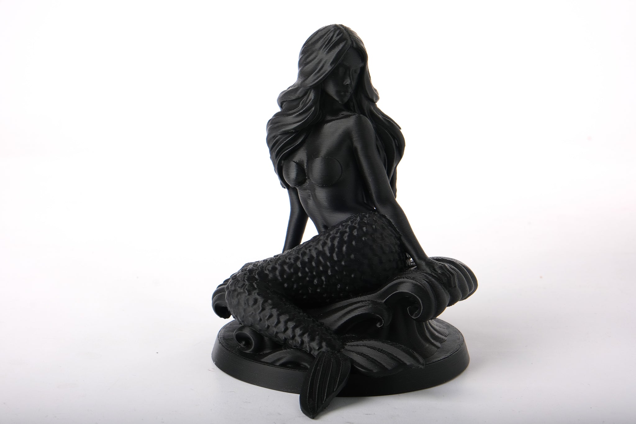 Mermaid bust sculpture styled on a wooden shelf alongside neutral ceramic objects and soft lighting