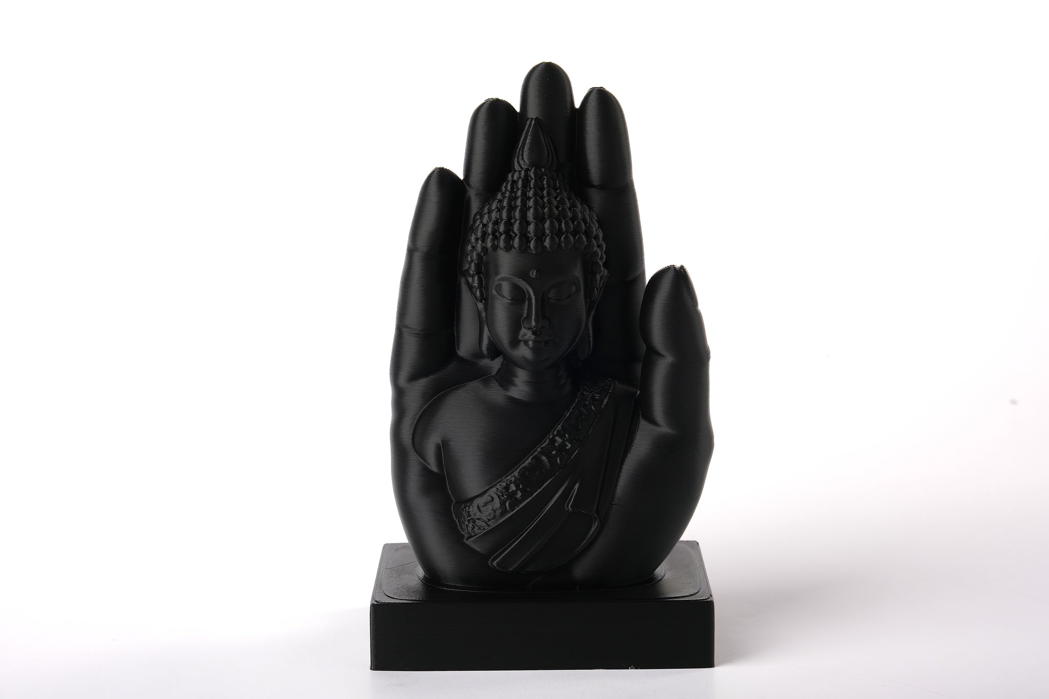 Buddha hand sculpture styled on a wooden shelf beside candles and dried botanicals in a calm meditation corner