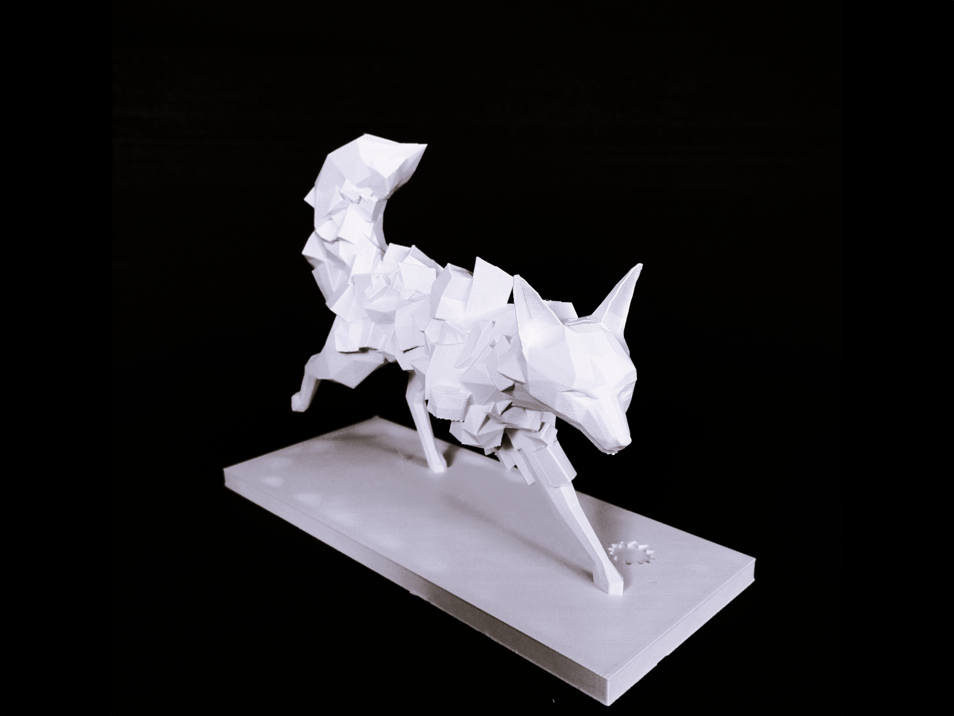 Geometric fox sculpture styled on a wooden shelf beside a ceramic vase and dried grasses