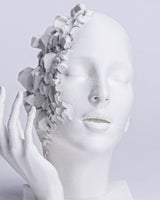 Close-up of shattered face sculpture showing geometric fragmentation and calm facial expression
