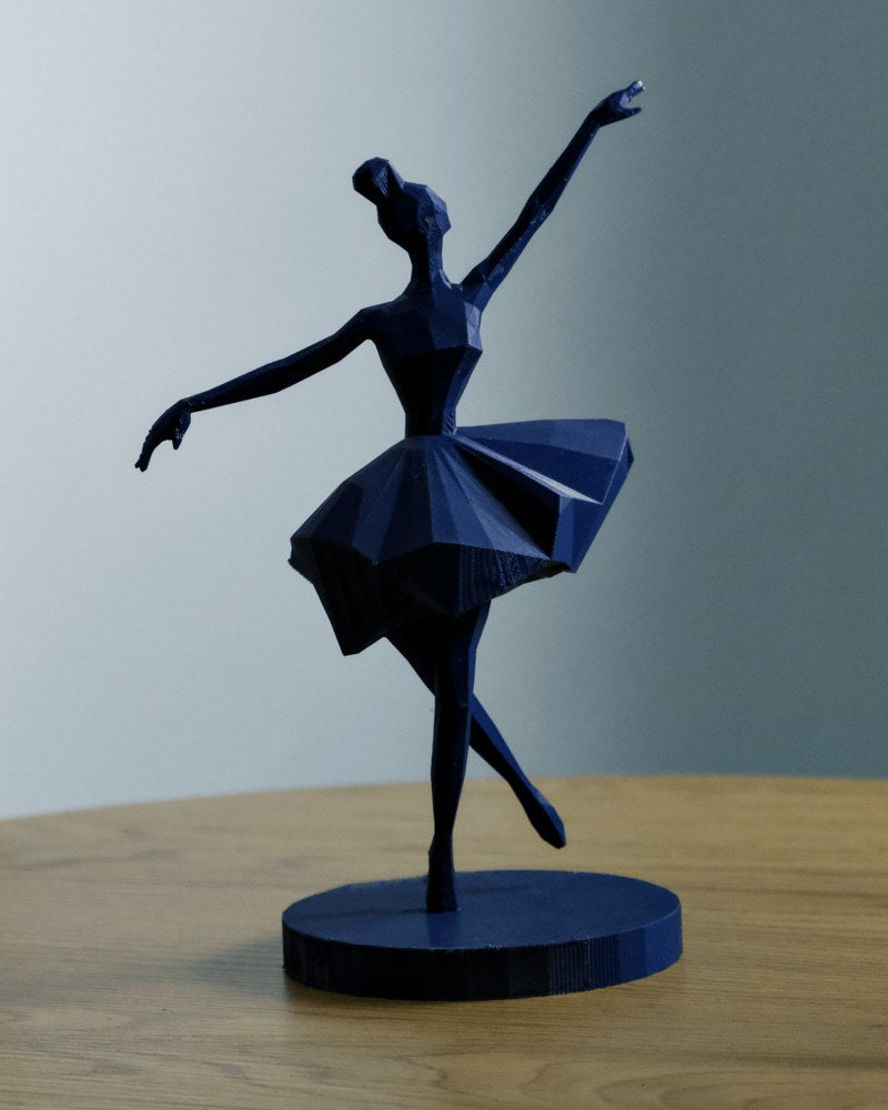Geometric ballerina sculpture in white, front view against neutral background, angular facets visible