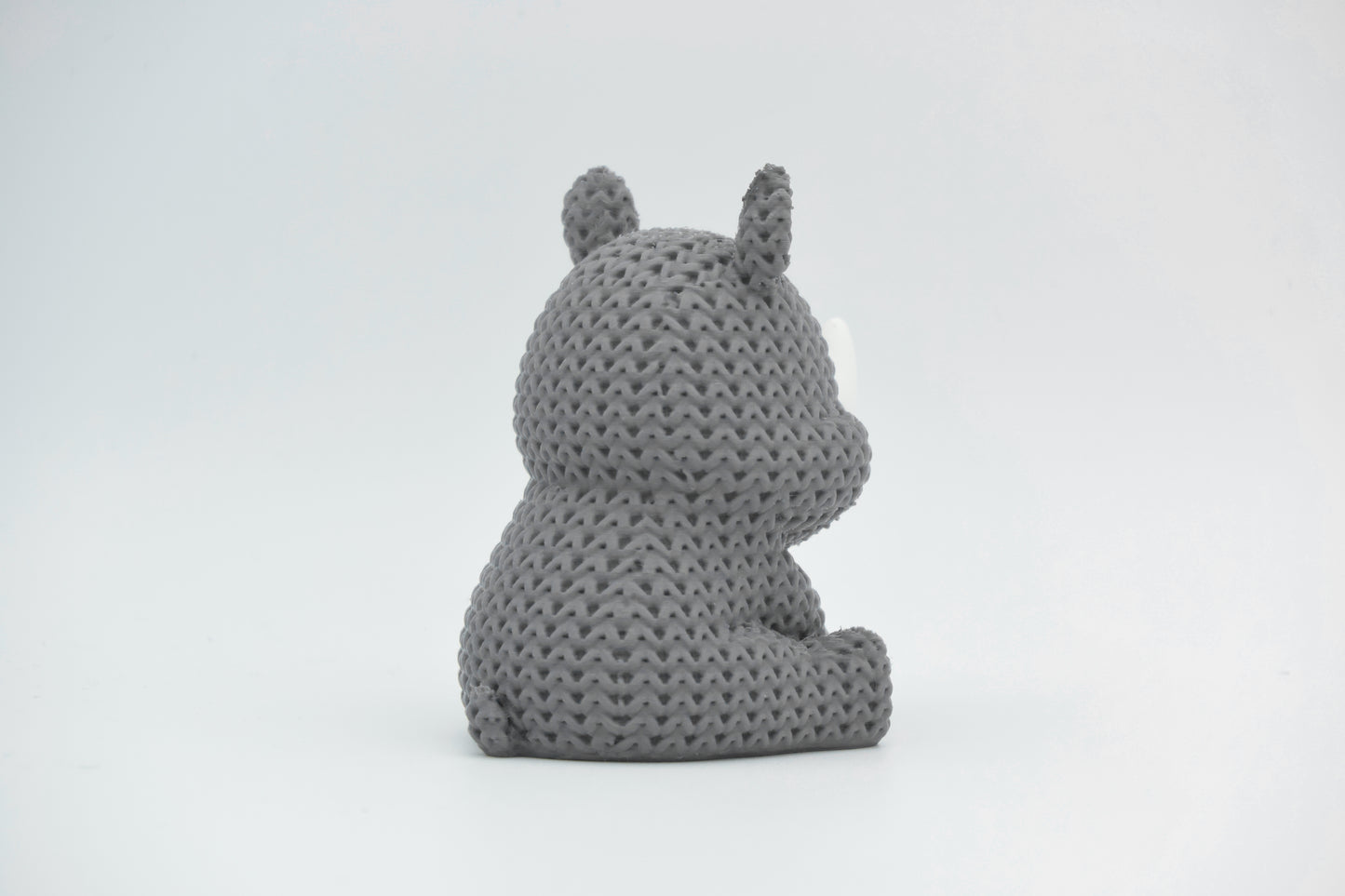 Detail of the knitted rhino surface texture showing the woven pattern and subtle ridge lines across the body