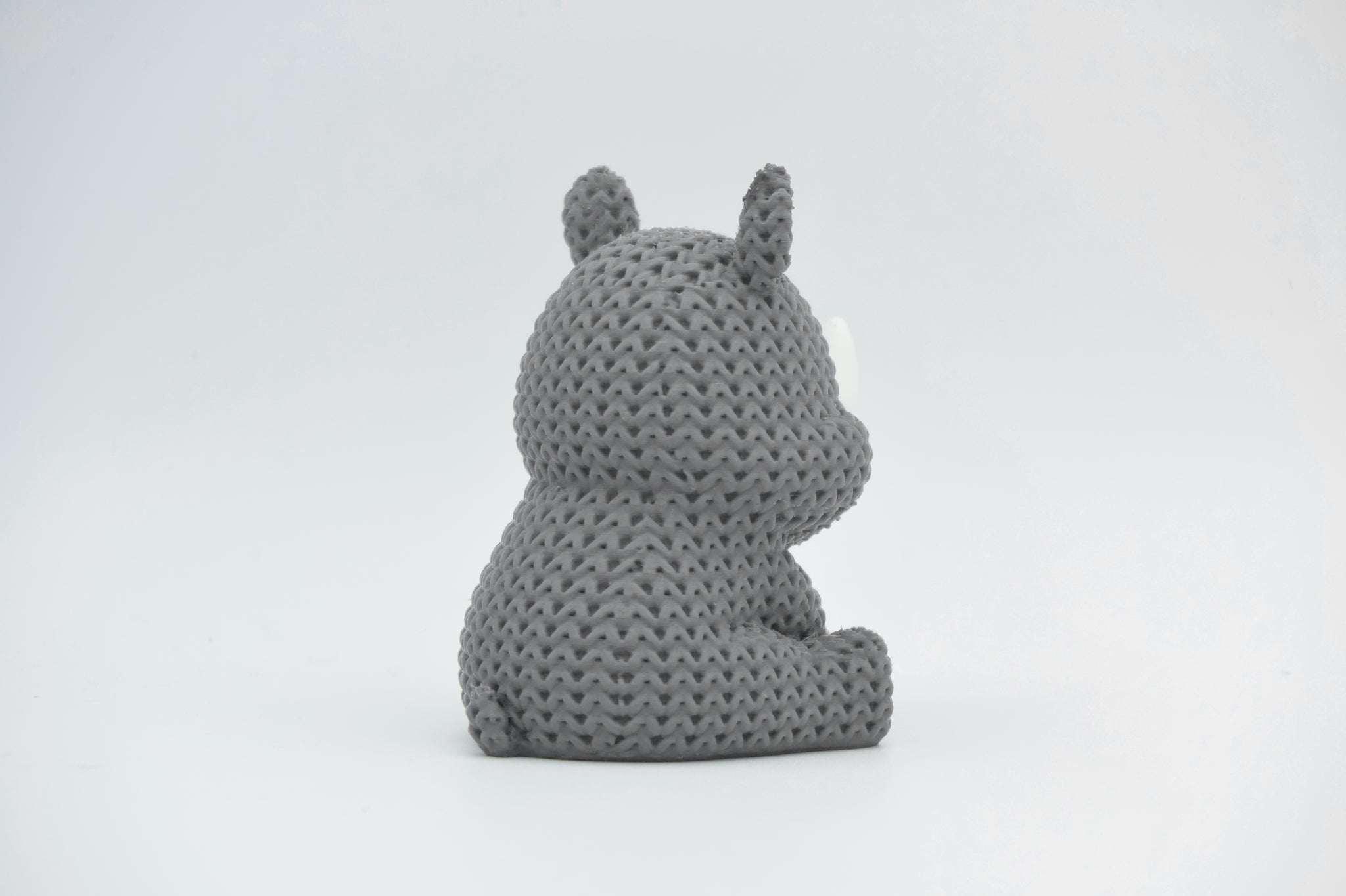 Detail of the knitted rhino surface texture showing the woven pattern and subtle ridge lines across the body