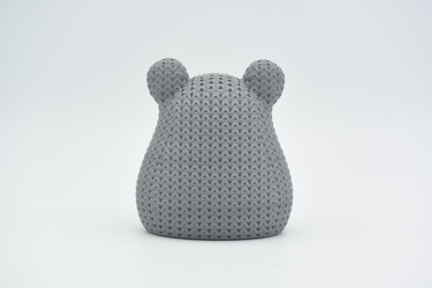 Texture detail of the knitted hamster surface showing the tight crochet-like stitch pattern across its back