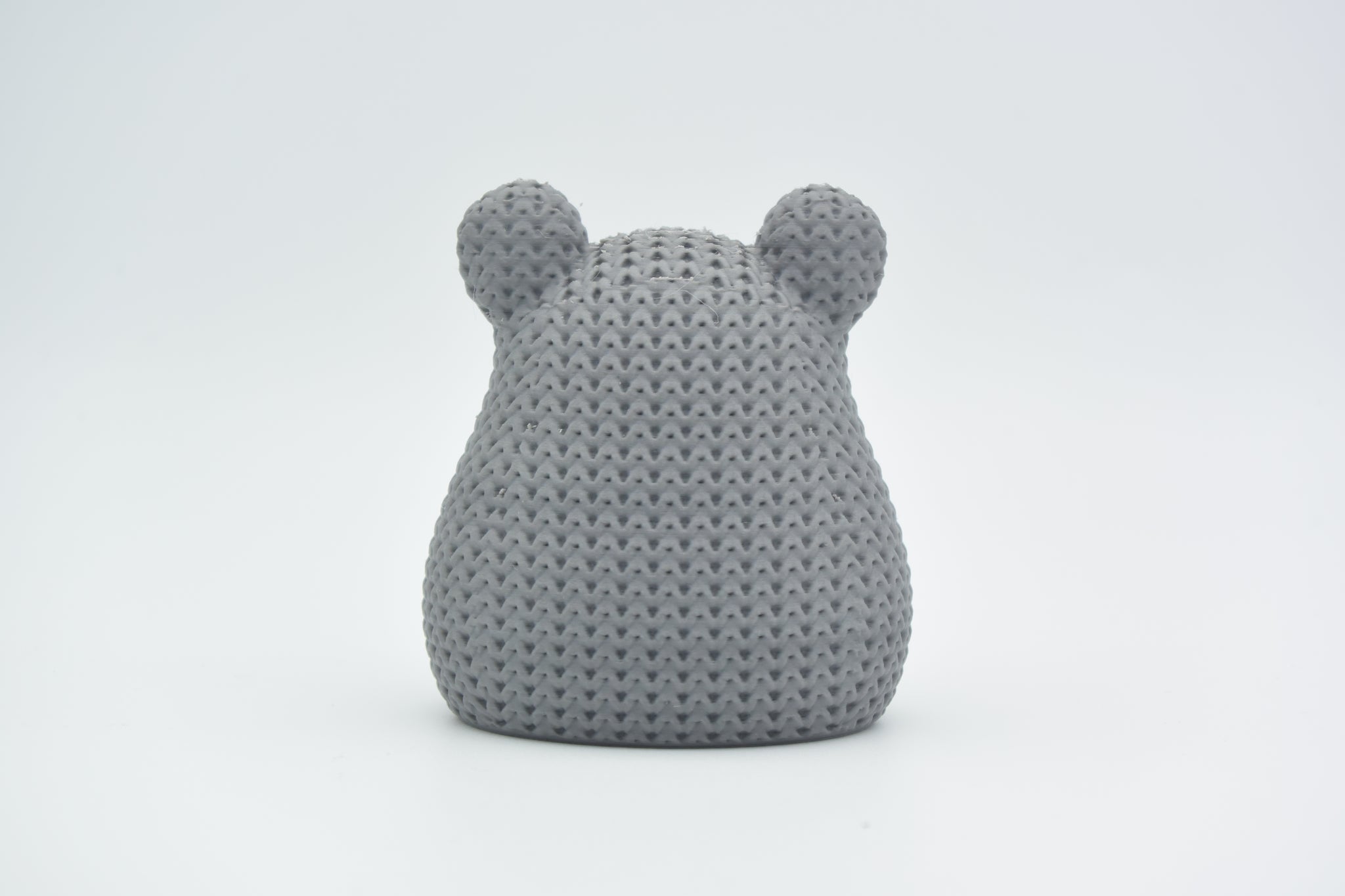 Texture detail of the knitted hamster surface showing the tight crochet-like stitch pattern across its back