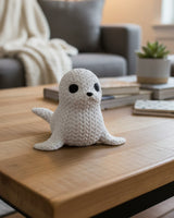 Close-up of a decorative knitted seal figurine with soft crochet-look texture and small dark eyes