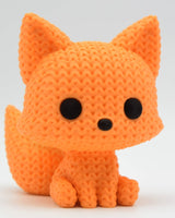 Close-up of a small knitted fox figurine with looped texture, hand-placed eyes and nose, 6 cm tall