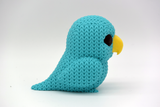Detail shot of the knitted texture on a small parrot figurine, showing the woven surface pattern up close