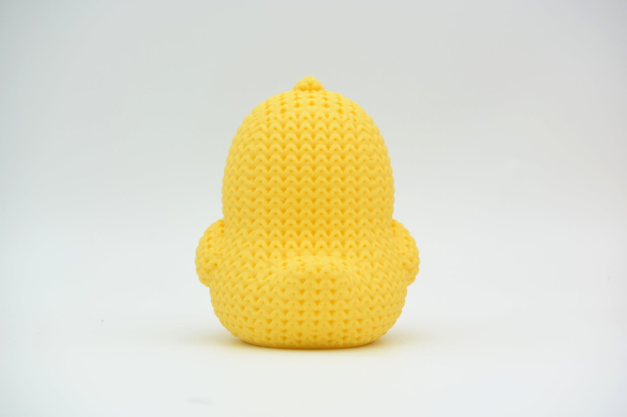Texture detail of knitted chick showing soft ribbed crochet-like surface pattern in yellow