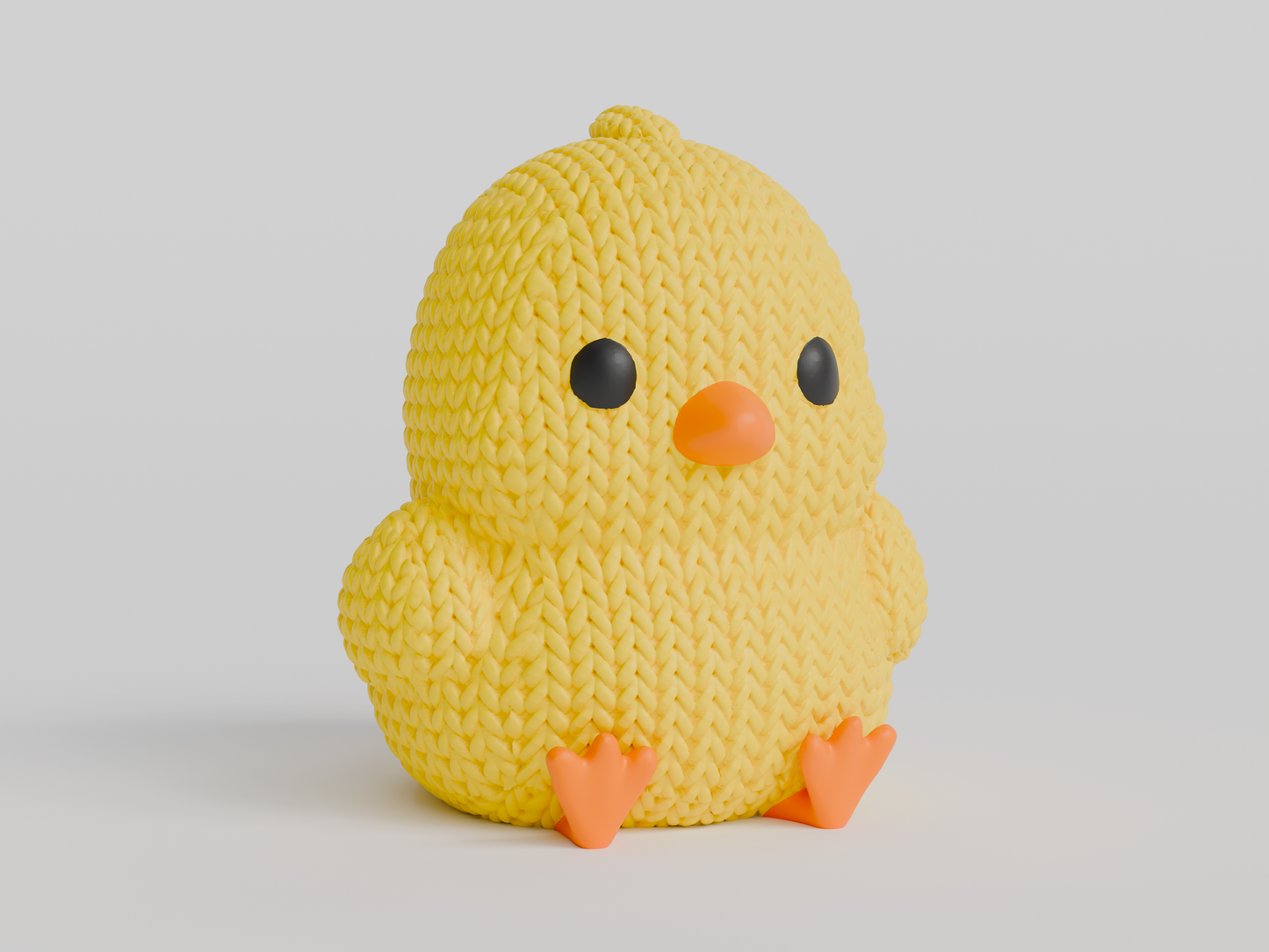 Close-up of a small knitted chick decoration with crochet texture, yellow with orange beak and feet