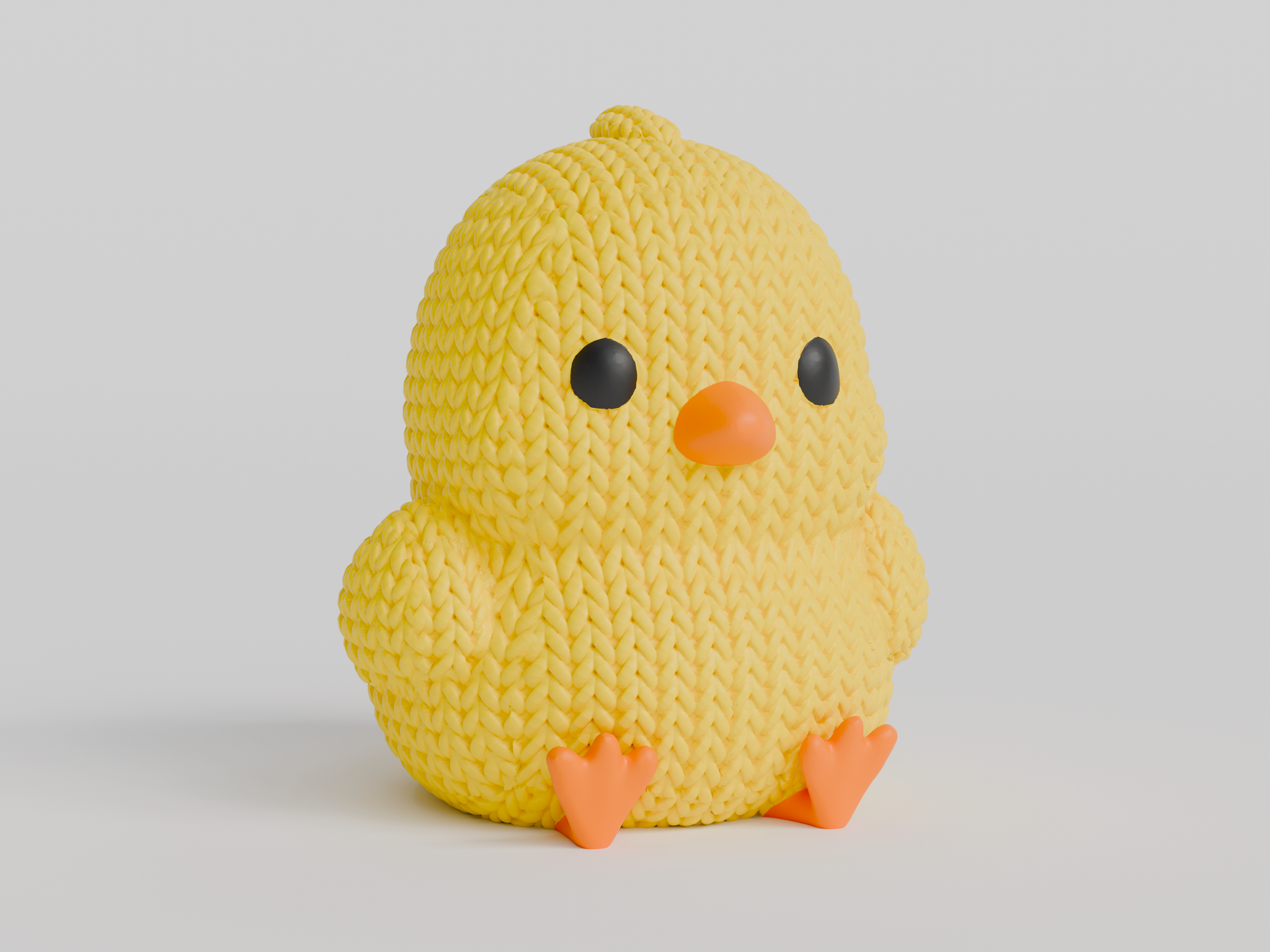 Close-up of a small knitted chick decoration with crochet texture, yellow with orange beak and feet