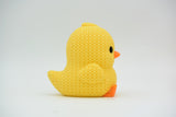 Close-up of a small knitted chick decoration with crochet texture, yellow with orange beak and feet