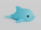 Close-up of a small knitted dolphin figurine with soft crochet-textured surface and round inset eyes