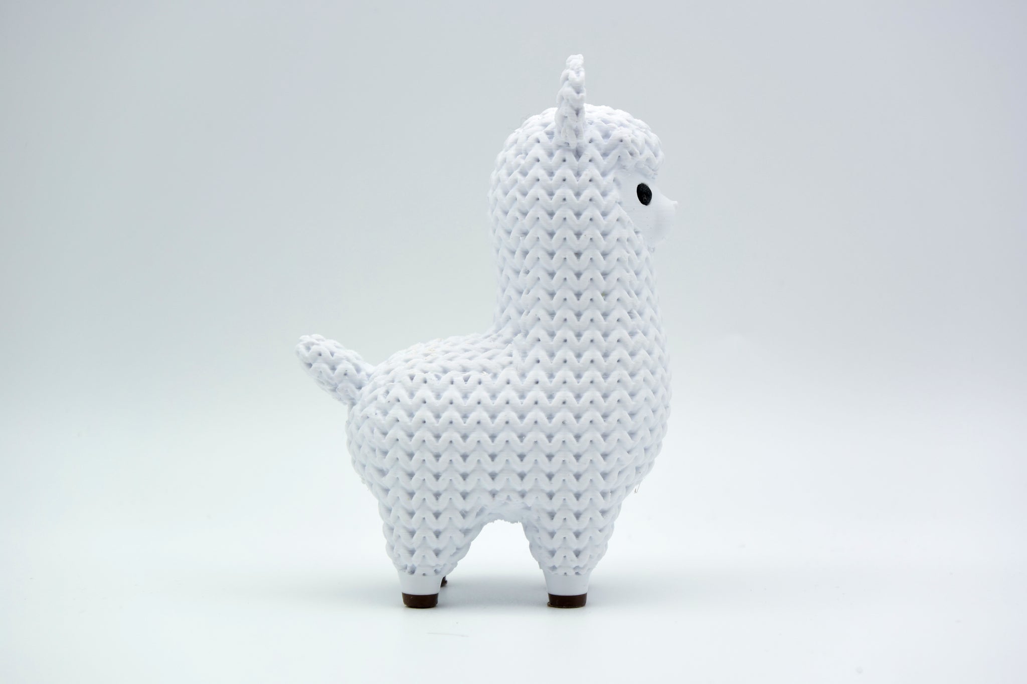 Texture detail of the knitted llama surface showing the raised yarn-like crochet pattern
