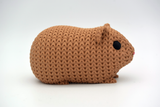 Macro detail of the looping crochet-like surface texture on a guinea pig figurine in warm neutral tones