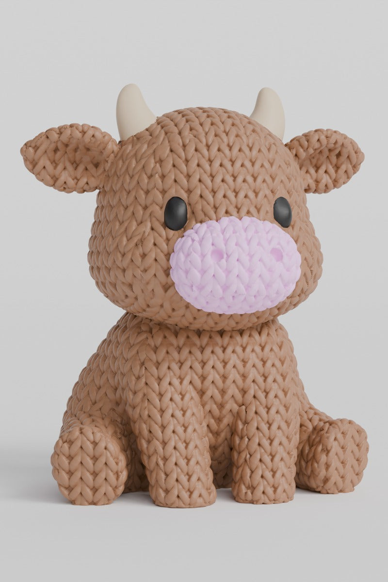 Close-up of a knitted cow decoration with a soft crochet-look texture in white and black
