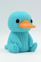 Close-up of a knitted platypus figurine with a soft crochet-look texture, seen from the front