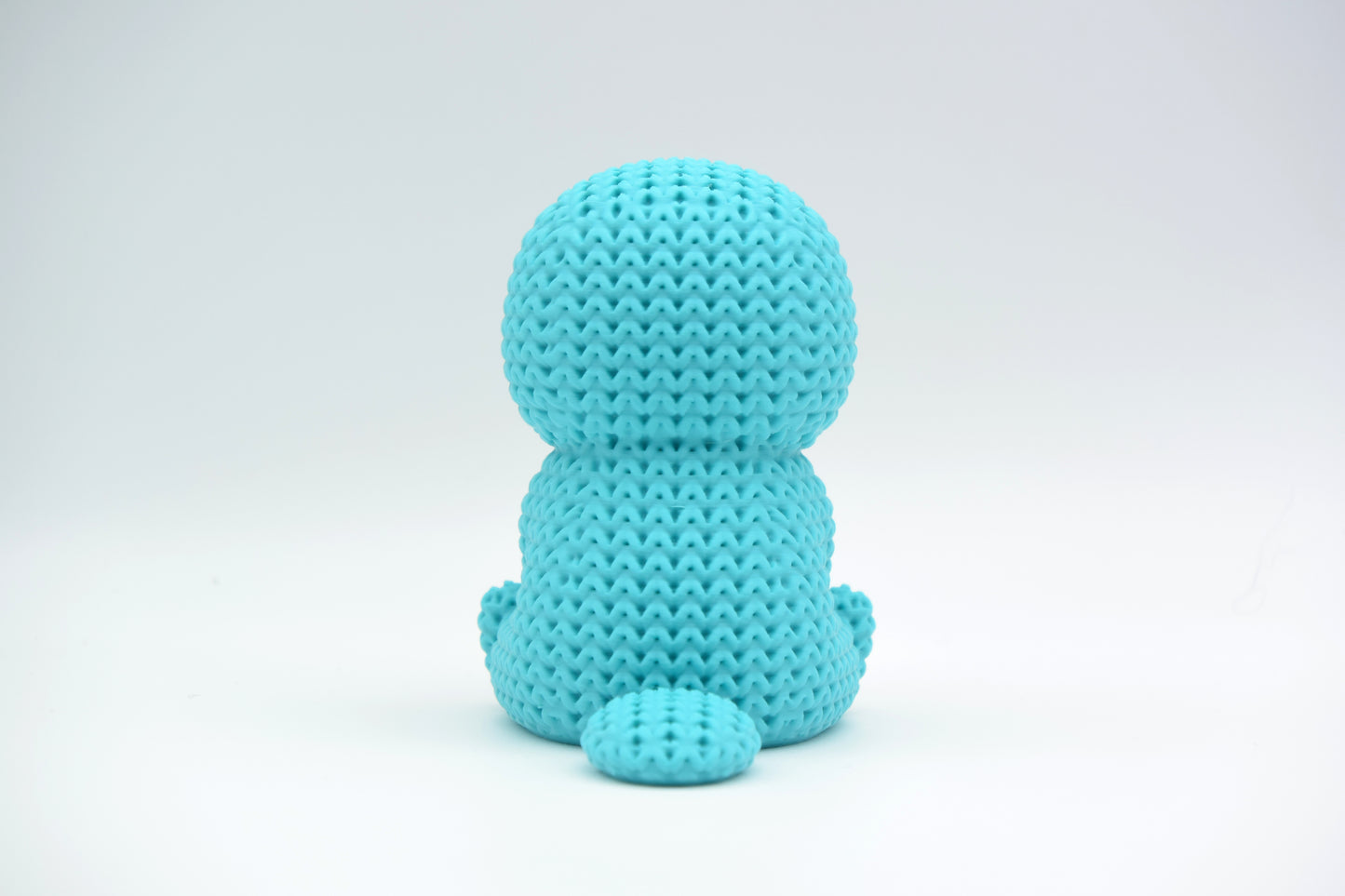 Close-up of a knitted platypus figurine with a soft crochet-look texture, seen from the front