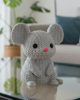 Close-up of a knitted mouse decoration with a soft crochet-look texture, small round ears and a curved tail
