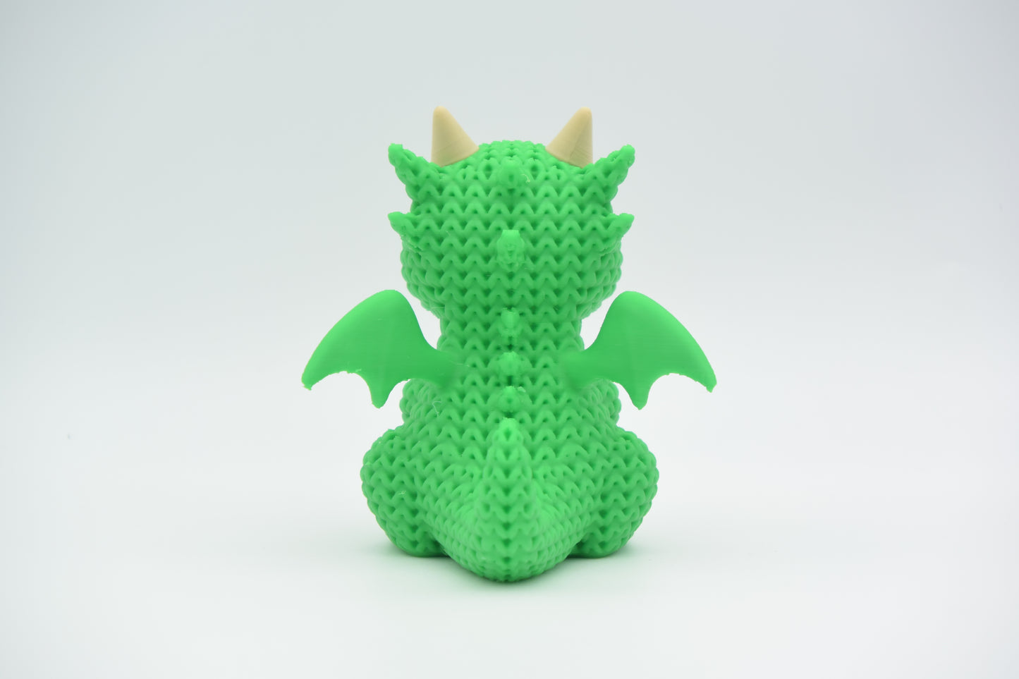 Detailed texture shot of the knitted dragon showing the looped crochet-like pattern across its body