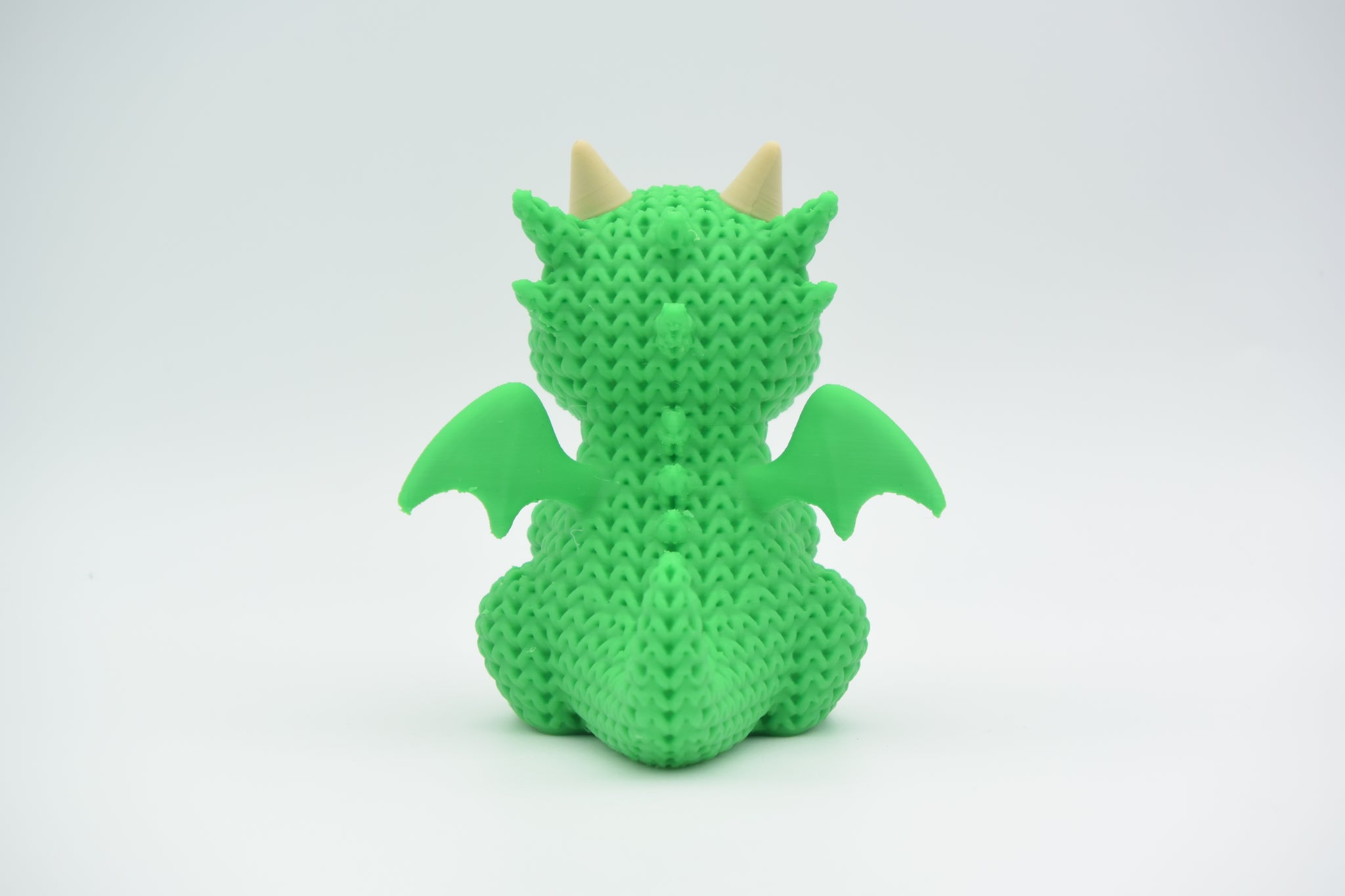 Detailed texture shot of the knitted dragon showing the looped crochet-like pattern across its body