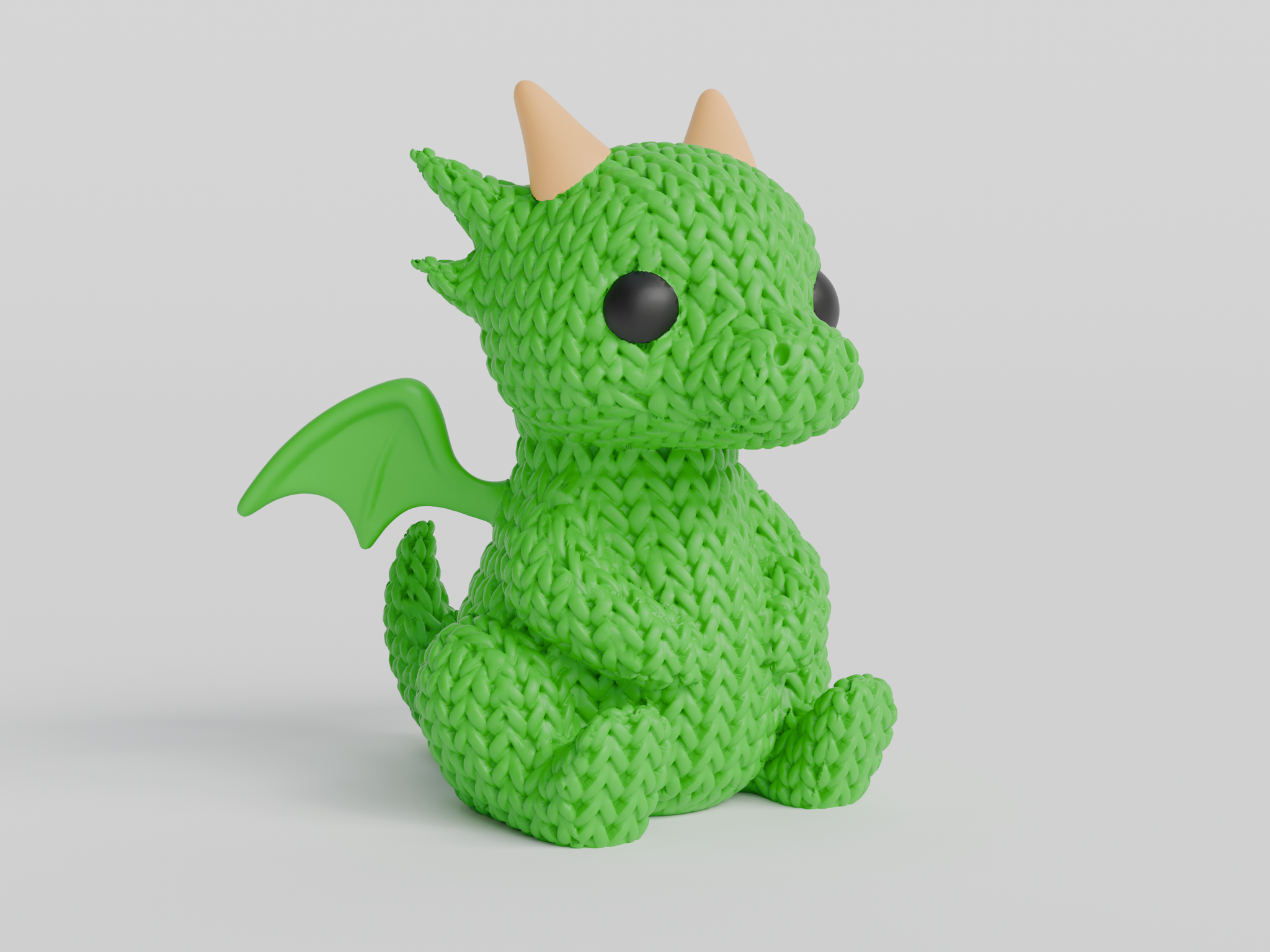 Close-up of a knitted dragon figurine with crochet-texture surface, shown against a light background